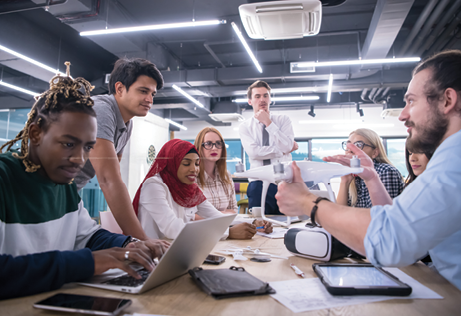 multiethnic startup business team discussing new business plan,working on laptop and tablet computer while learning about drone technology for new business advancement
