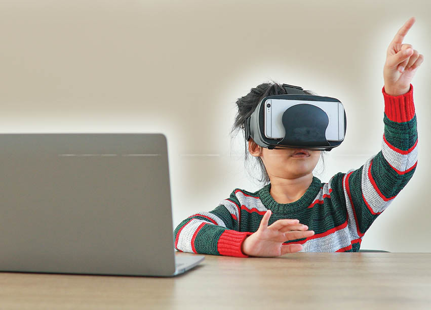 The little girl wearing VR sitting at desk in the home glasses virtual Global Internet connection metaverse. Future kids in white clothing wearing VR headsets for a game. concept advanced technology. 