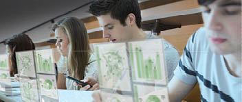 Focused students working on their digital tools in lecture hall